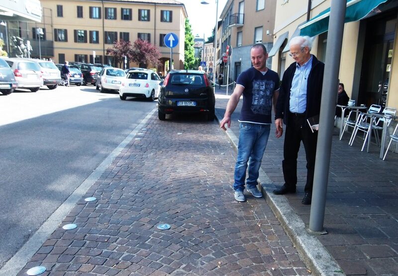 Carate. Il titolare del bar Centrale indica i vetri per terra delle auto danneggiate (Foto Marzorati)