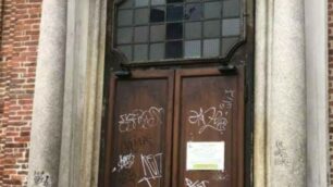 Il portone della chiesa imbrattato: sono visibili anche le scritte sulle colonne