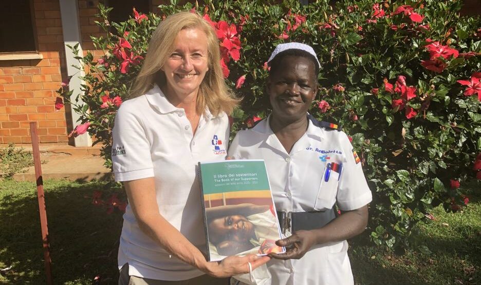 Nel giardino dell'ospedale St. Mary di Lacor Dominique Corti con suor Angioletta mostra il libro dei sostenitori